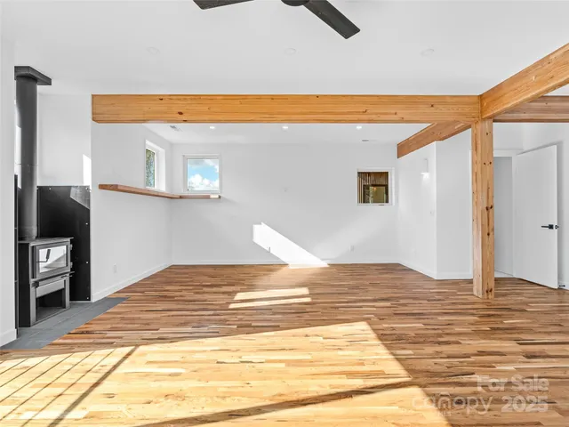 a view of a livingroom with wooden floor and a refrigerator