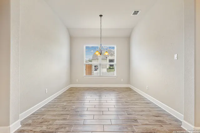 a view of a room with window wooden floor and kitchen view