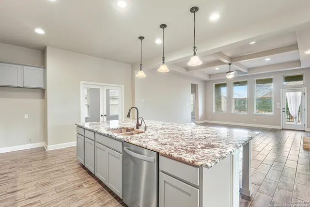 a kitchen with center island wooden floor and a sink
