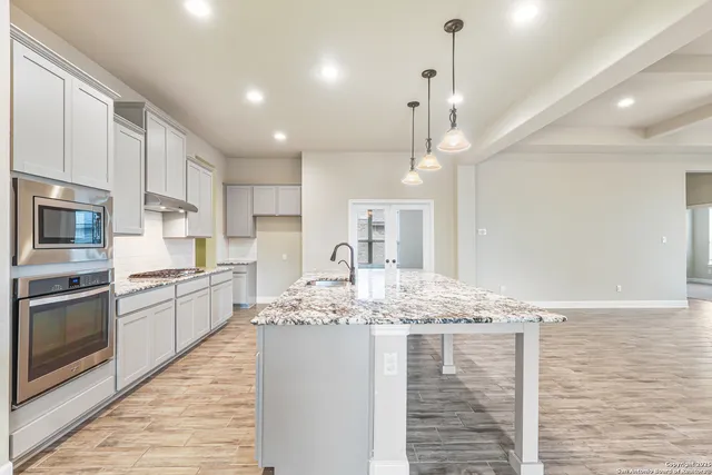 a large kitchen with kitchen island a sink stainless steel appliances and cabinets