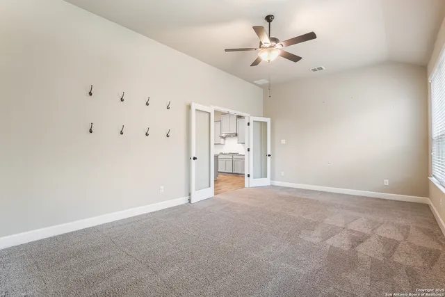 an empty room with closet and a ceiling fan