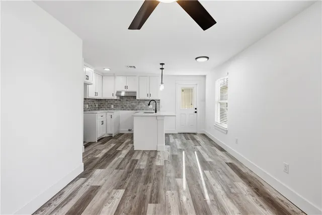 a large kitchen with a lot of white cabinets and stainless steel appliances