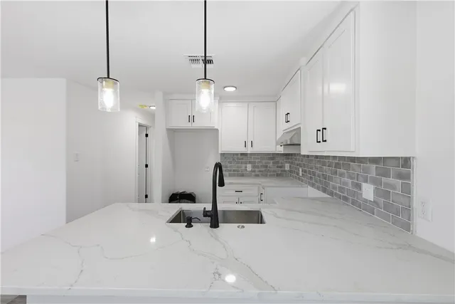 a view of a kitchen with a sink and chandelier