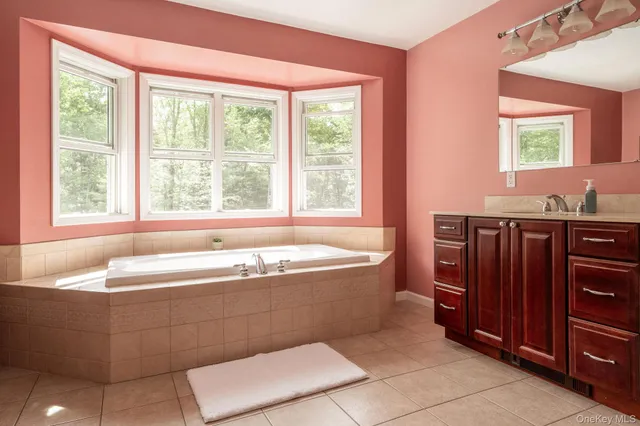 a bathroom with a tub a sink and a window