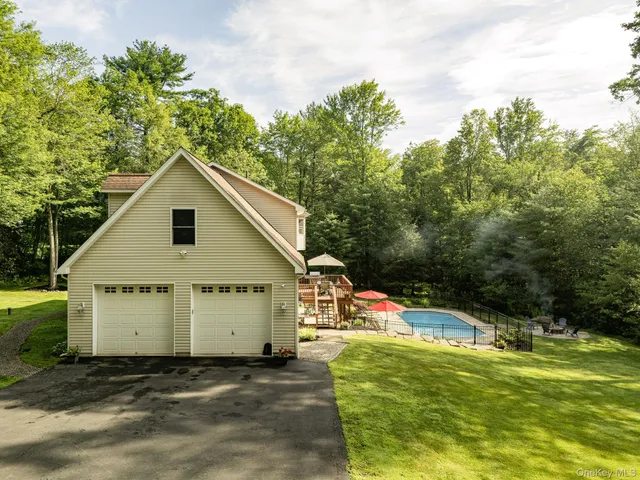 a view of a house with pool and a yard