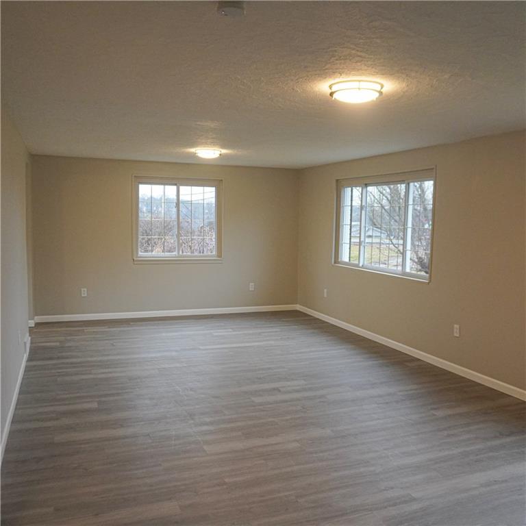 216 Roberts Road Pittsburgh, PA 15239 - Photo 6 of 17 an empty room with wooden floor and windows