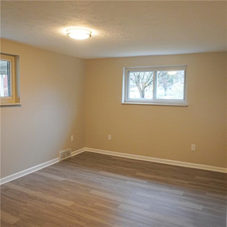 216 Roberts Road Pittsburgh, PA 15239 - Photo 10 of 17 a view of an empty room with wooden floor and a window