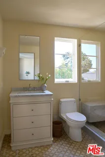 a bathroom with a toilet a sink and mirror