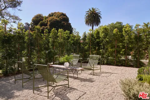 a view of a chairs and table in backyard