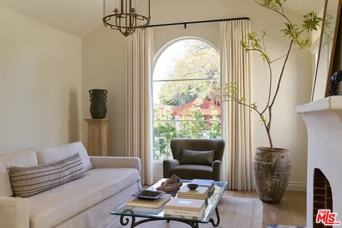 a living room with furniture a flat screen tv and a window