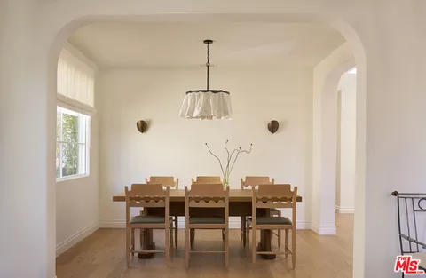 a dining room with furniture window and wooden floor