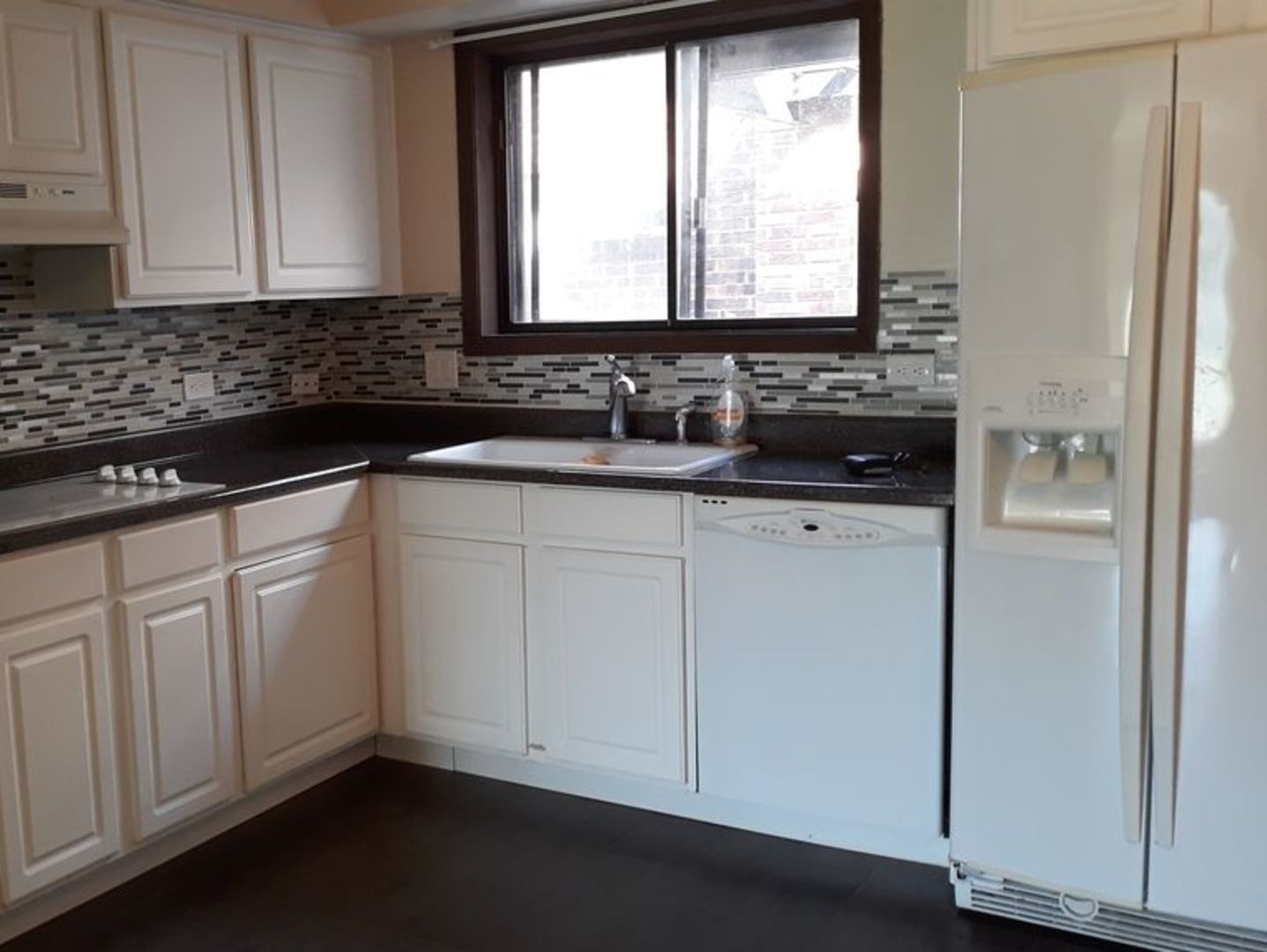 955 North Rohlwing Road, Unit 101A Addison, IL 60101 - Photo 4 of 13 a kitchen with white cabinets and a window