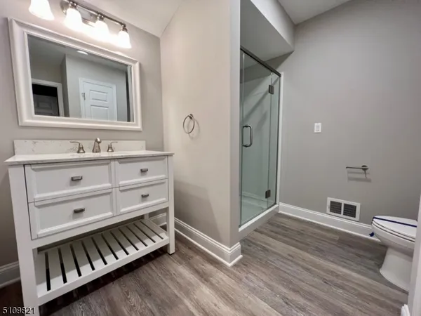 a view of bathroom with a toilet a sink and a mirror