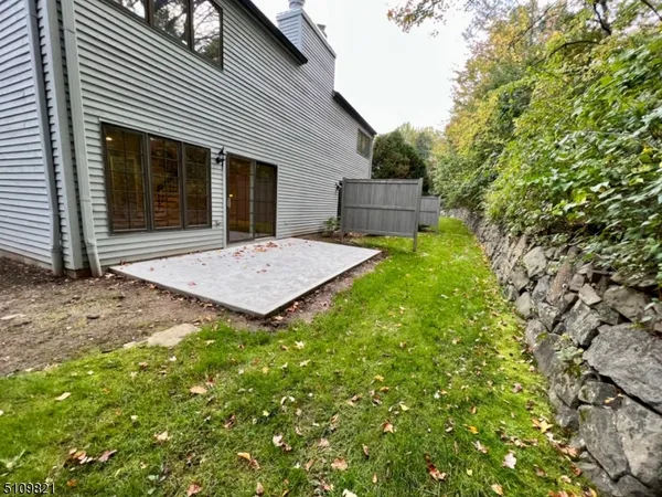 a view of a house with a small yard and large tree
