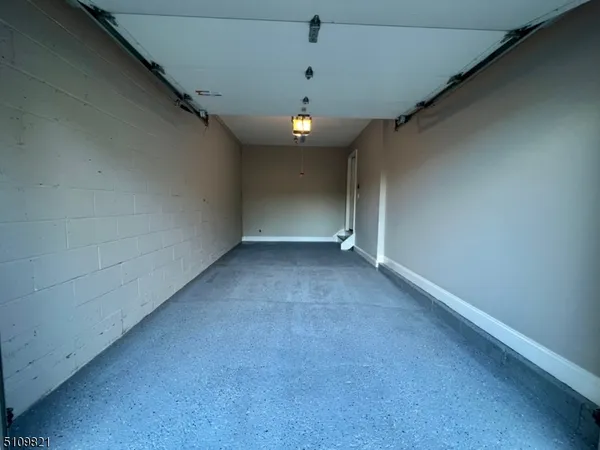 an empty room with a chandelier fan and windows