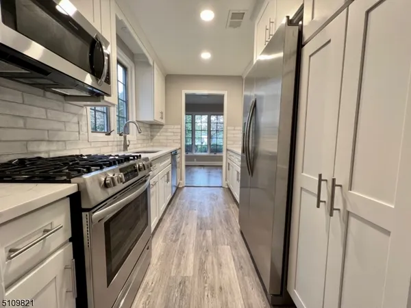 a kitchen with stainless steel appliances granite countertop a stove and a refrigerator