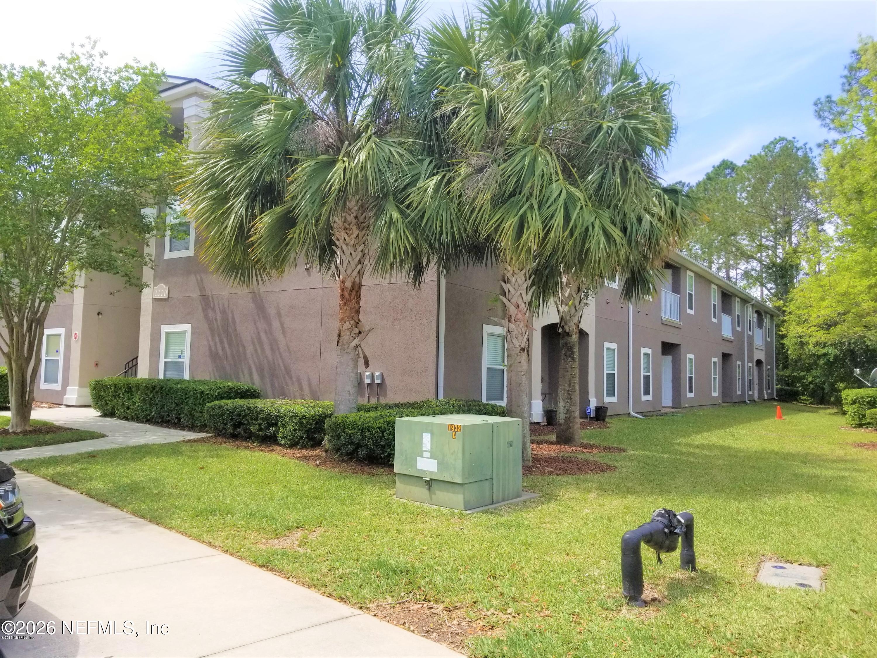 7920 Merrill Road, Unit 2004 Jacksonville, FL 32277 - Photo 11 of 13 a front view of a house with garden and trees