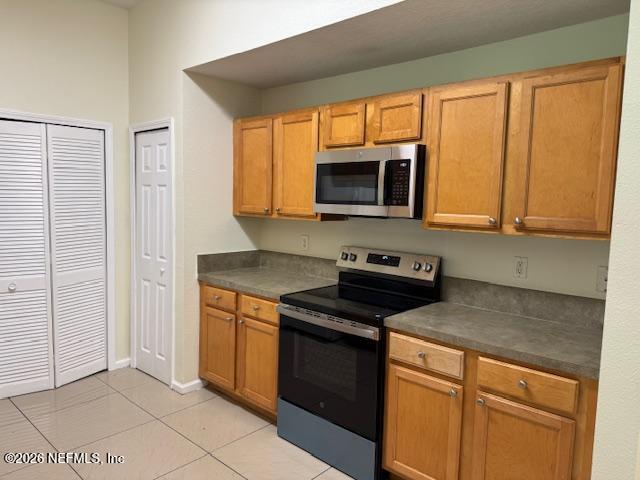 7920 Merrill Road, Unit 2004 Jacksonville, FL 32277 - Photo 5 of 13 a kitchen with stainless steel appliances granite countertop a stove microwave and refrigerator