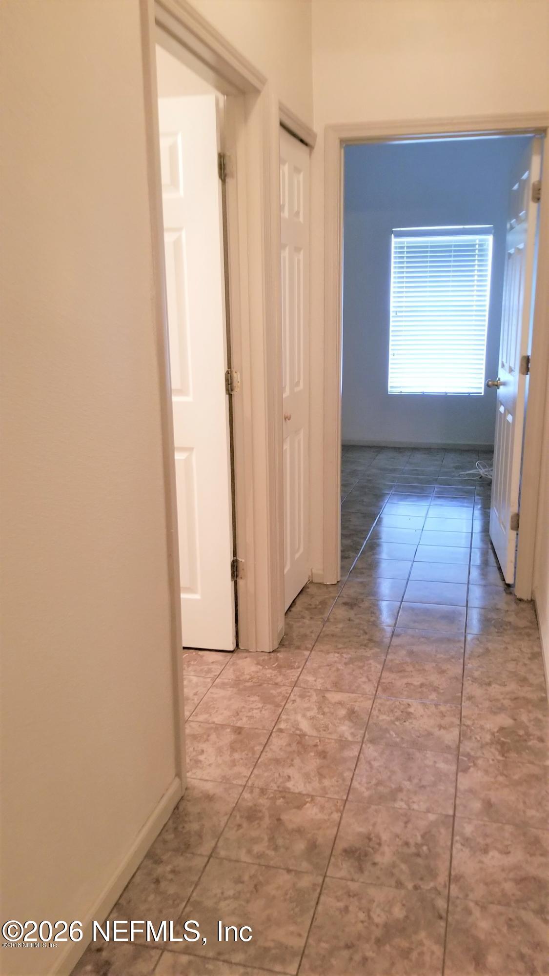 7920 Merrill Road, Unit 2004 Jacksonville, FL 32277 - Photo 7 of 13 a view of a hallway with wooden floor and a bathroom