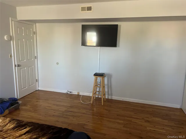 a view of a livingroom with wooden floor and a flat screen tv