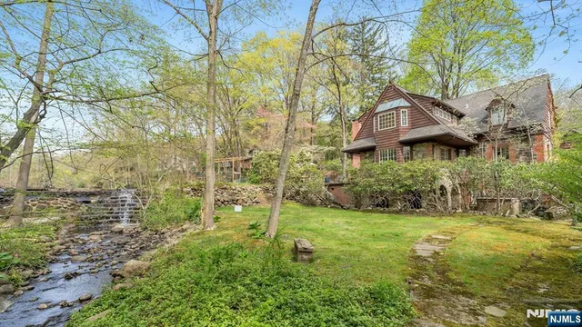 a aerial view of a house with yard and trees in the background