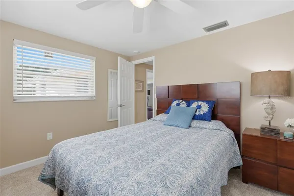 a bed sitting in a bedroom next to a lamp