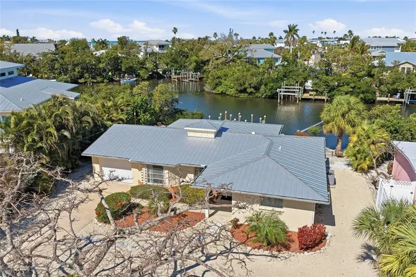 an aerial view of ocean and residential houses with outdoor space