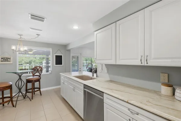 a kitchen with granite countertop white cabinets and white appliances