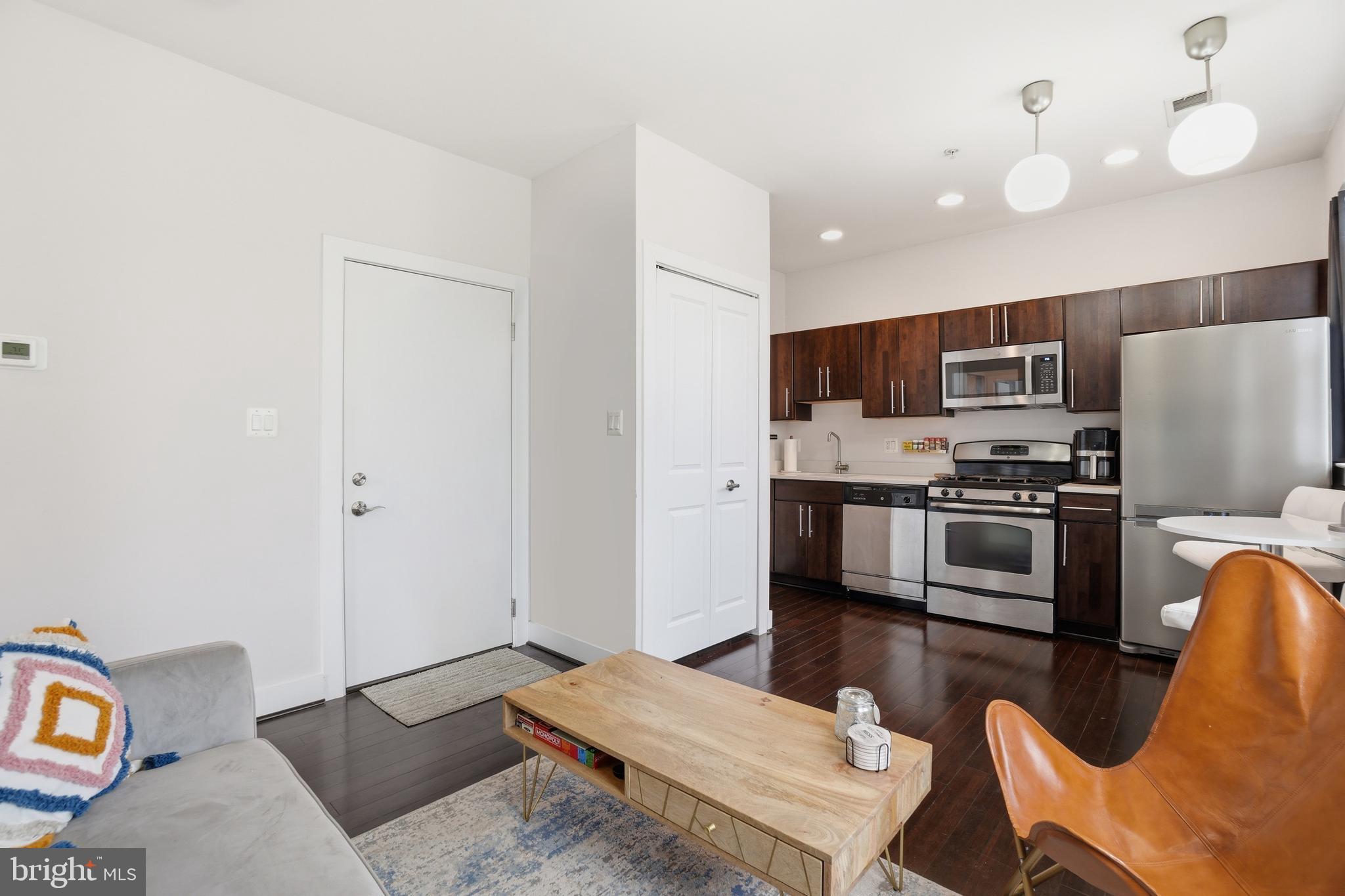 315 G Street Northeast, Unit 306 Washington, DC 20002 - Photo 3 of 14 a kitchen with stainless steel appliances kitchen island granite countertop a refrigerator stove top oven and sink