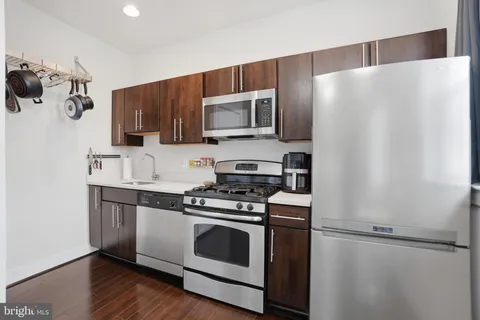 a kitchen with stainless steel appliances a refrigerator sink and microwave