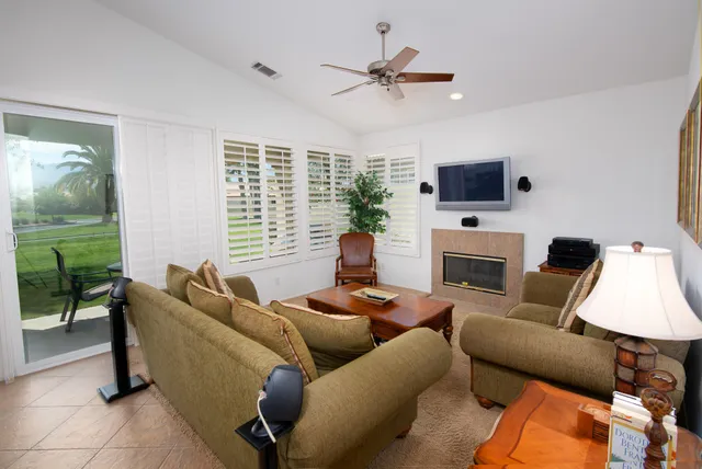 a living room with furniture a fireplace and a flat screen tv