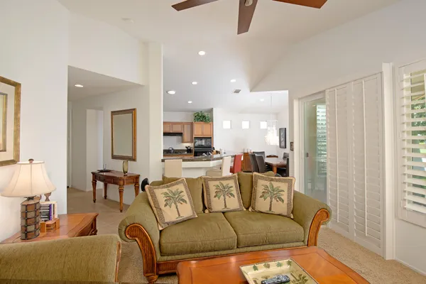a living room with furniture and a view of kitchen