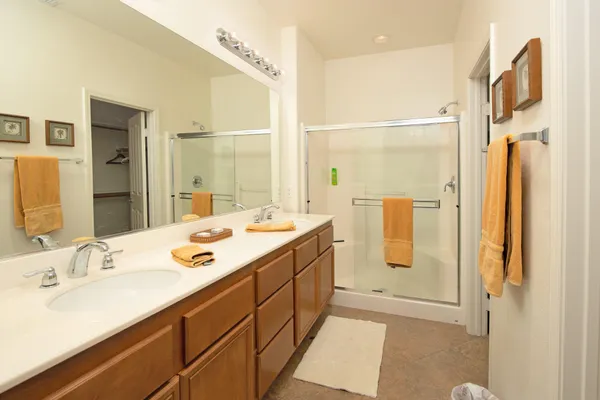 a bathroom with a double vanity sink mirror and shower