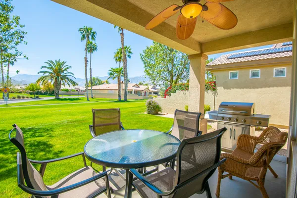 a view of a chairs and table in patio with a backyard