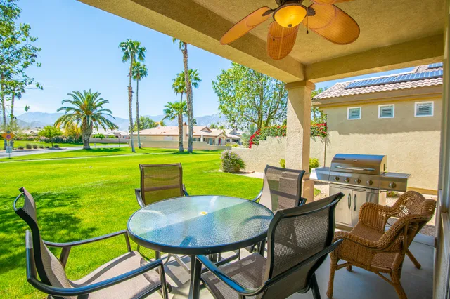 a view of a chairs and table in patio with a backyard