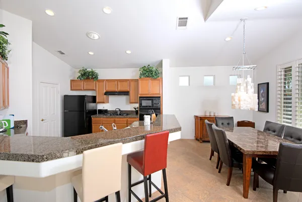 a kitchen with granite countertop kitchen island dining table and chairs