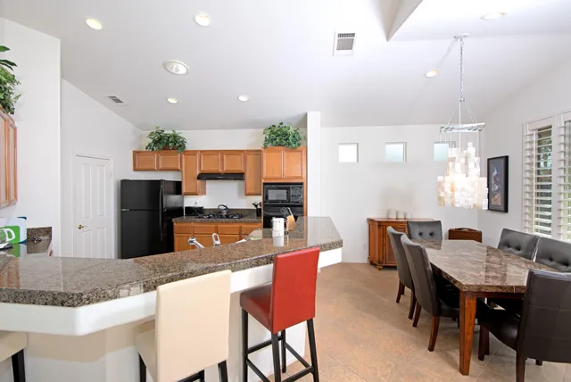 a kitchen with granite countertop kitchen island dining table and chairs