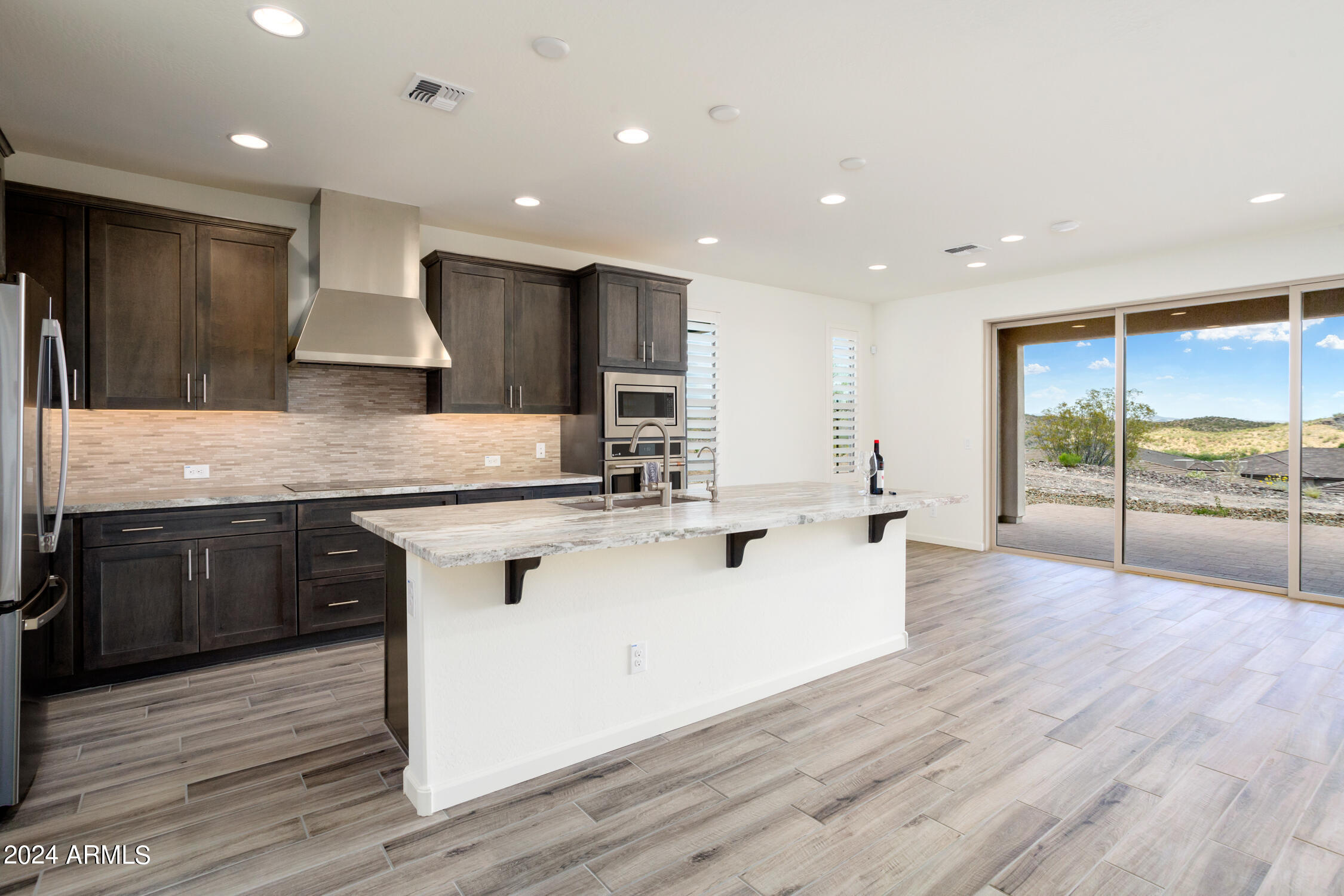 4092 Prairie Schooner Road Wickenburg, AZ 85390 - Photo 15 of 30 a large kitchen with stainless steel appliances granite countertop a lot of counter space and wooden floors
