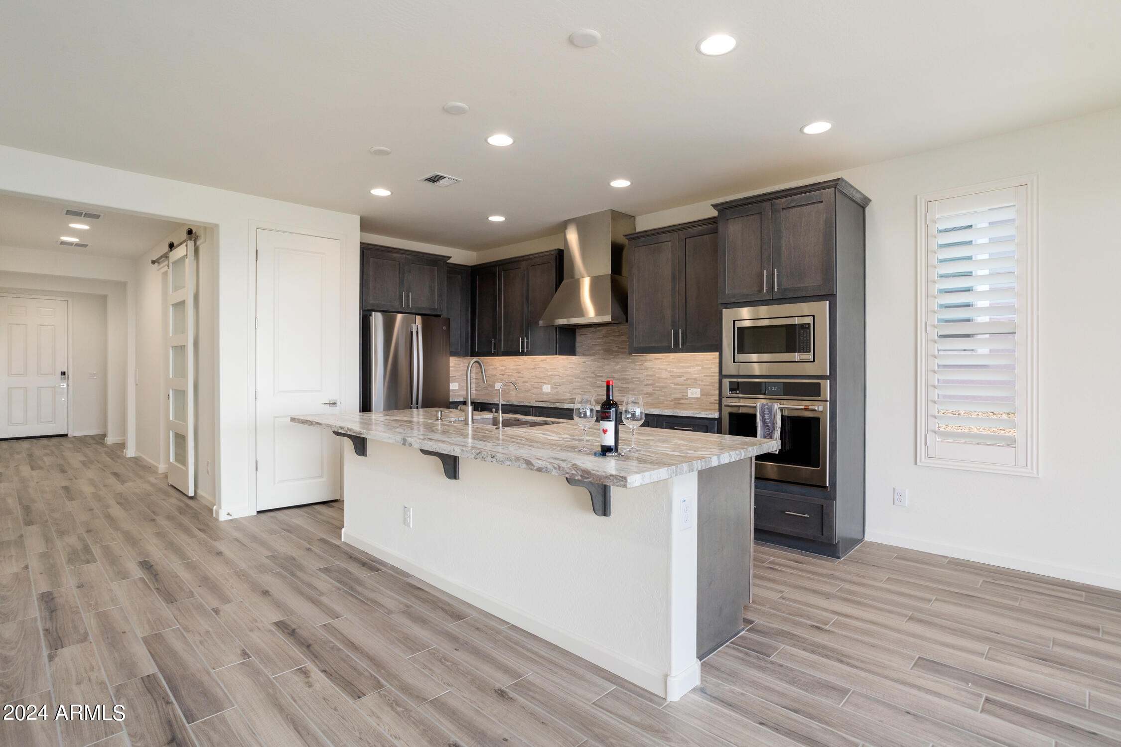 4092 Prairie Schooner Road Wickenburg, AZ 85390 - Photo 16 of 30 a kitchen with stainless steel appliances kitchen island granite countertop a refrigerator and a stove top oven
