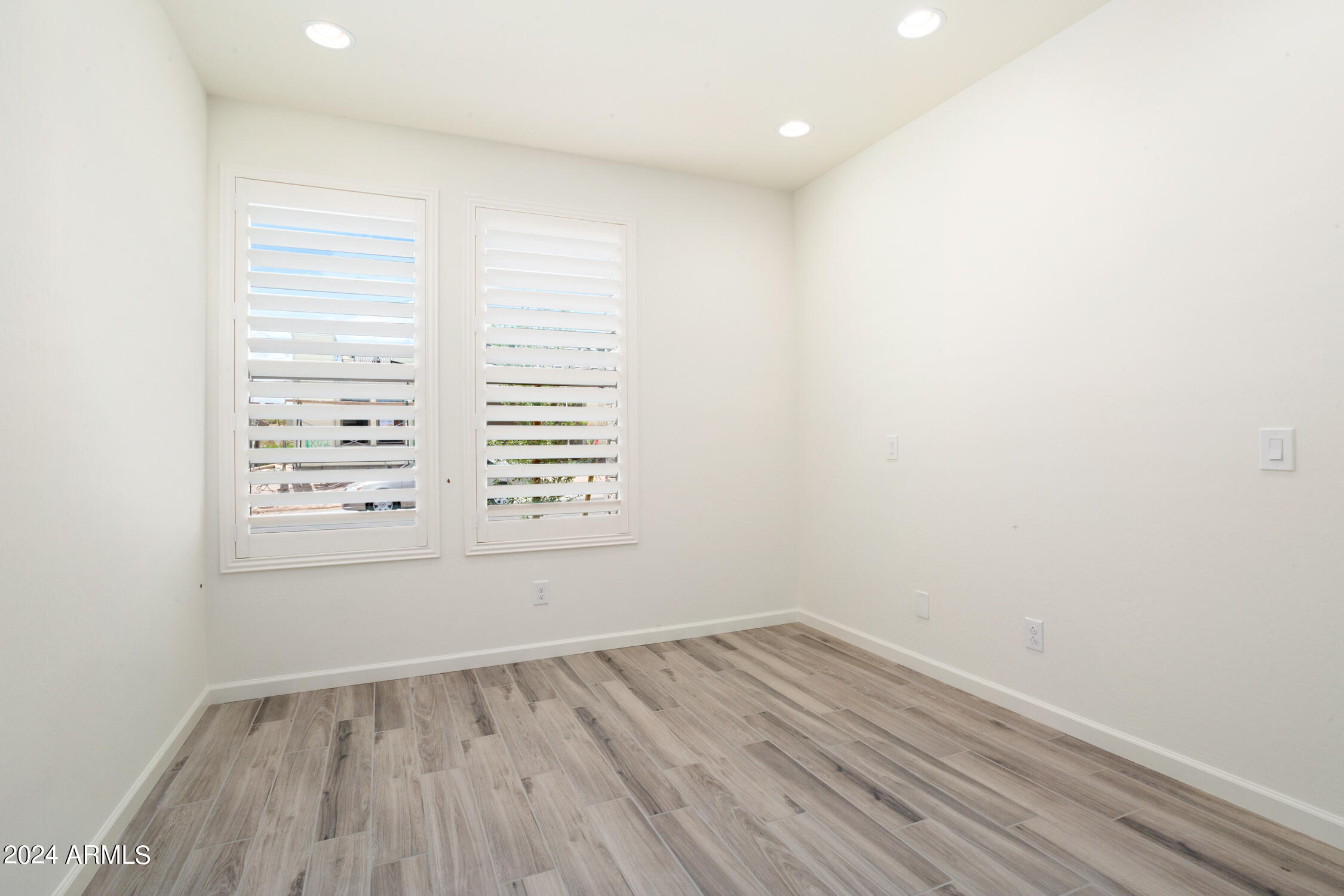 4092 Prairie Schooner Road Wickenburg, AZ 85390 - Photo 24 of 30 an empty room with wooden floor and windows