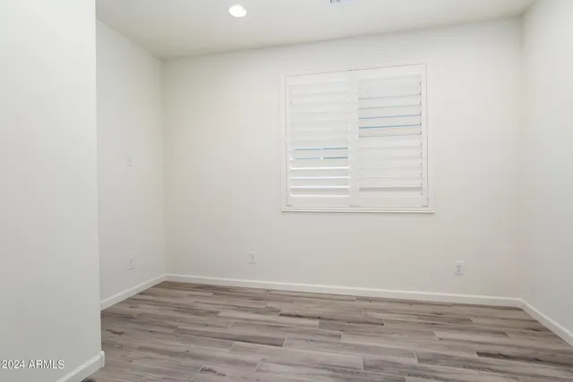 a view of a small space with wooden floor and a window
