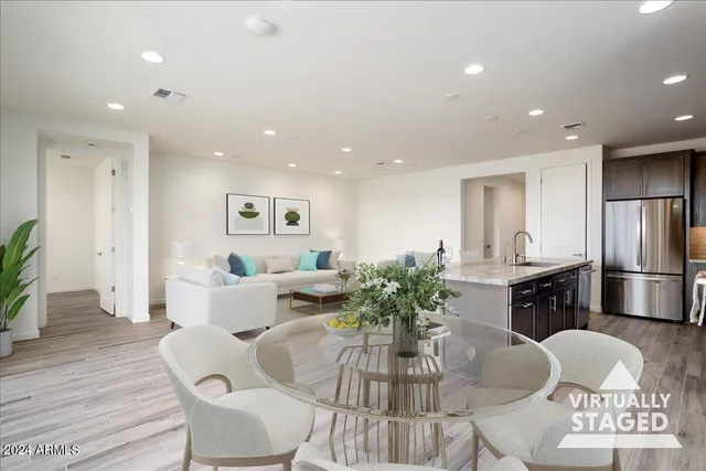 a living room with furniture potted plant and kitchen view