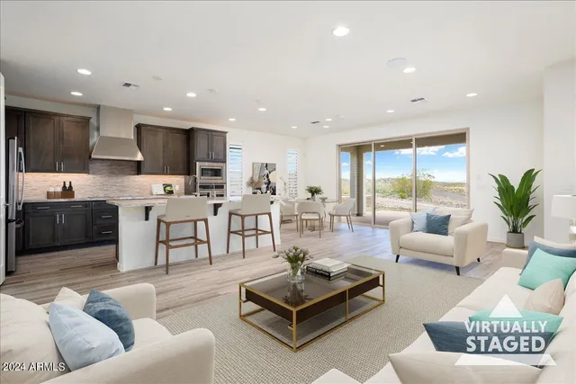 a living room with furniture kitchen view and a large window