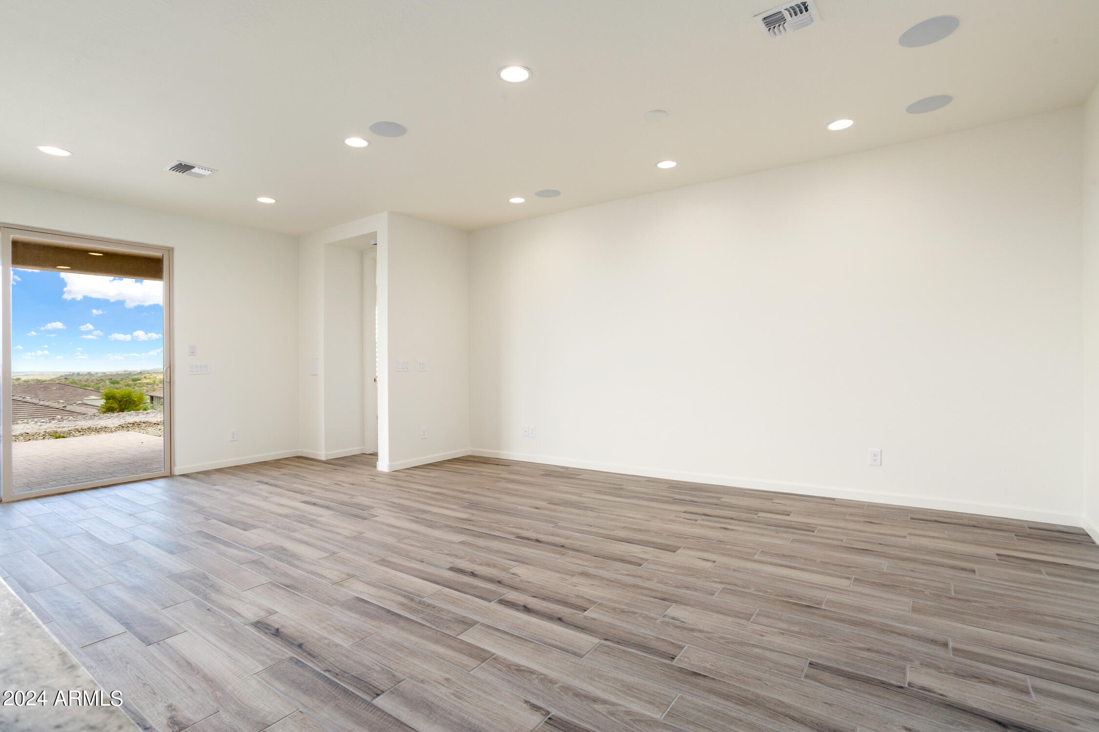 4092 Prairie Schooner Road Wickenburg, AZ 85390 - Photo 9 of 30 a view of an empty room with wooden floor and a window