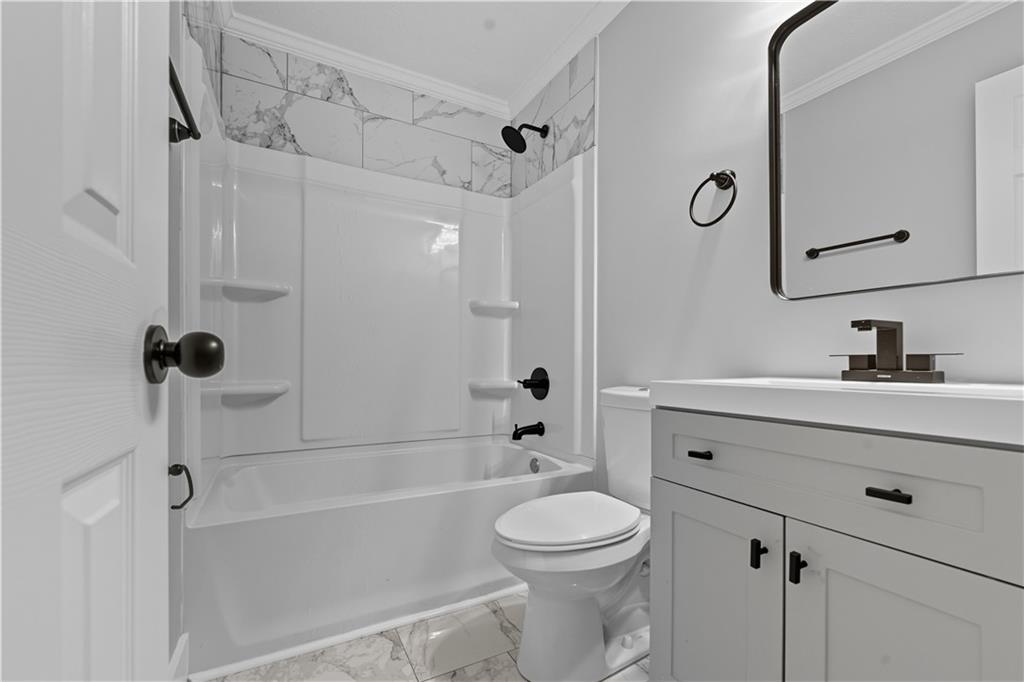 2087 Chestnut Way Lithia Springs, GA 30122 - Photo 16 of 28 a bathroom with a sink a toilet a mirror a bathtub and shower