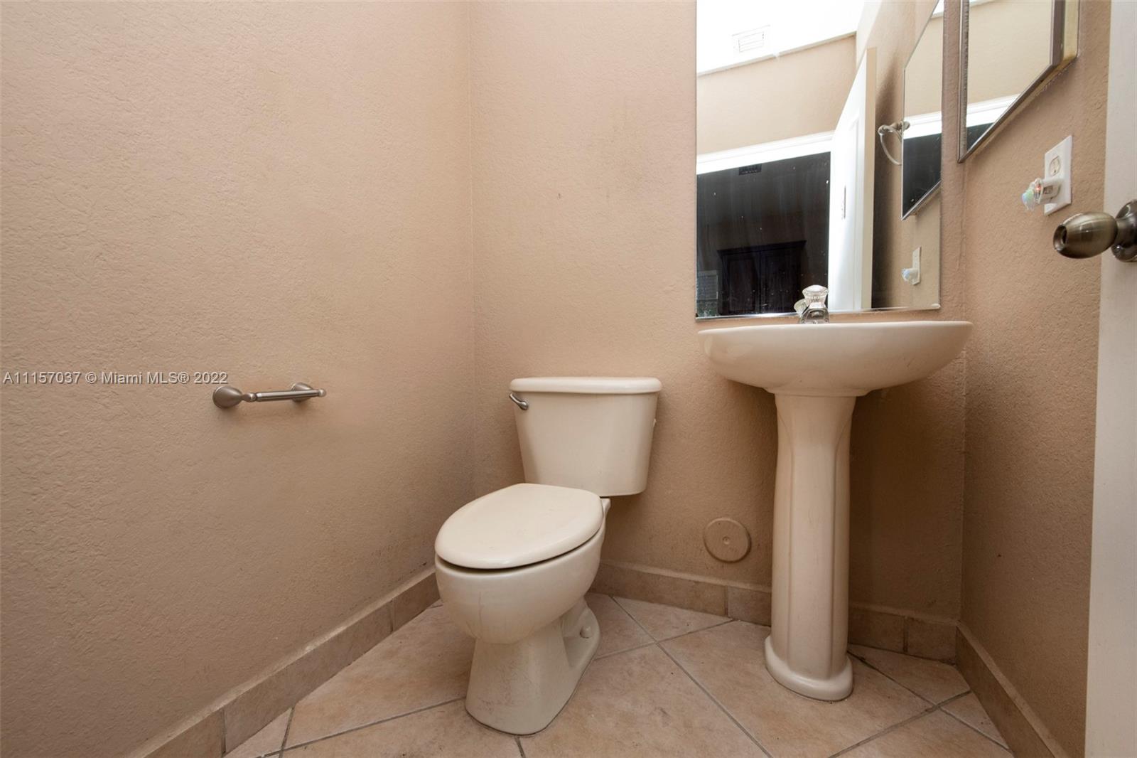 14738 Southwest 9th Lane Miami, FL 33194 - Photo 11 of 30 a bathroom with a toilet sink and mirror