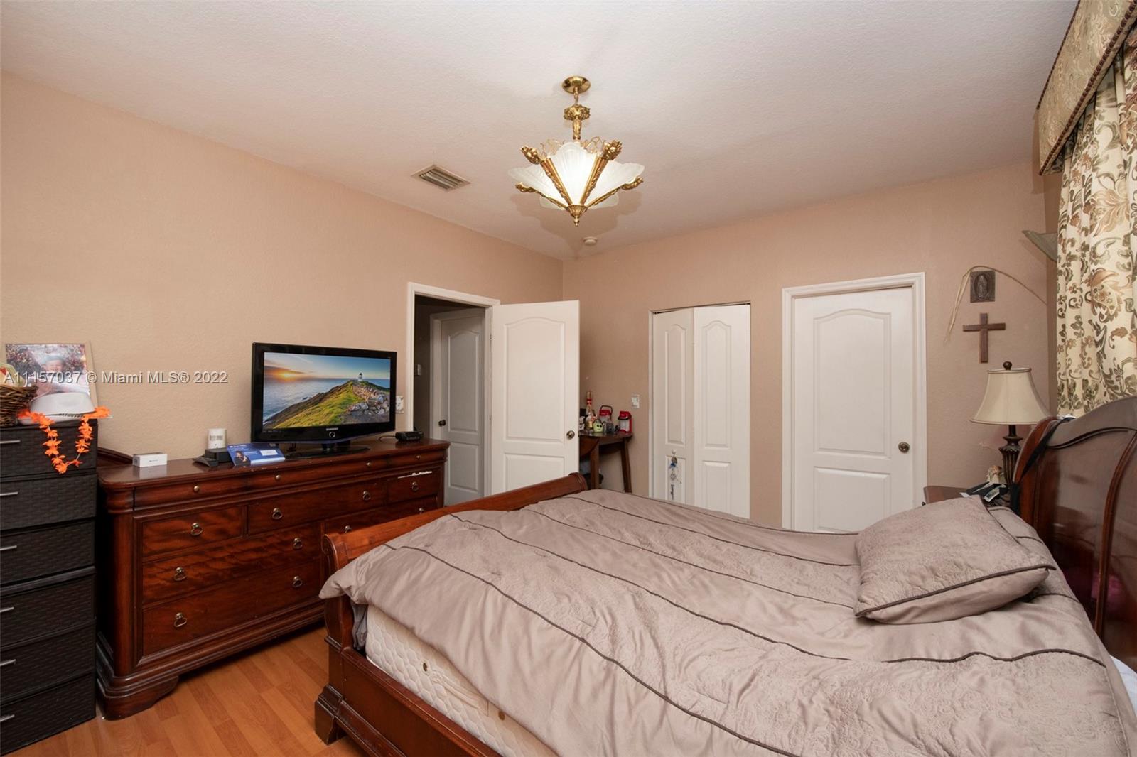 14738 Southwest 9th Lane Miami, FL 33194 - Photo 14 of 30 a bedroom with a bed and a flat screen tv