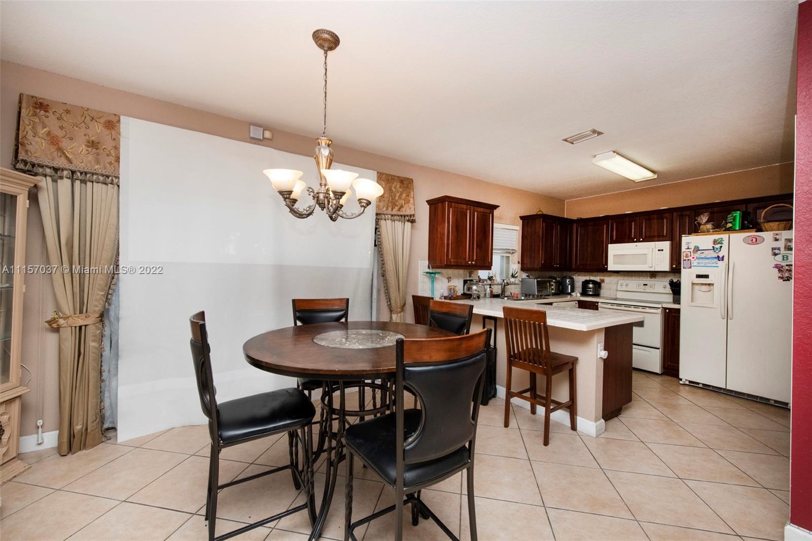 14738 Southwest 9th Lane Miami, FL 33194 - Photo 8 of 30 a dining room filled chandelier and kitchen view