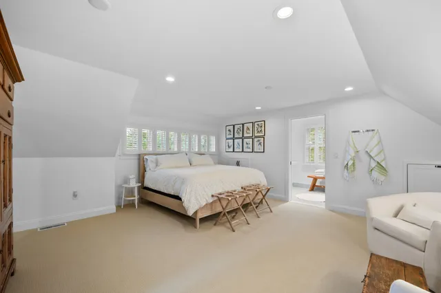 a spacious bedroom with a bed couch and dresser