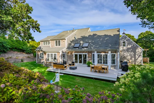 a front view of a house with sitting area and garden